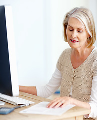 Image showing Mature woman at desk with computer, paperwork and administration for business accounting. Report, review and senior businesswoman reading invoice documents for finance, budget and office management