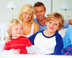 Image showing Happy, portrait and parents with boys on bed for bonding, relaxing and spending time together. Smile, love and young mother and father resting with kids from Australia in bedroom at family home.