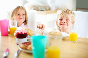 Image showing Smile, kitchen and children eating breakfast together for healthy, wellness and diet meal. Happy, laughing and kid siblings bonding and enjoying lunch or brunch with juice at table in family home.