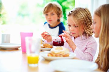 Image showing Family, morning and breakfast jam, children and meal for nutrition, orange juice and bagel. Brother, sisters and enjoying food together for hunger, health and energy for home weekend activities