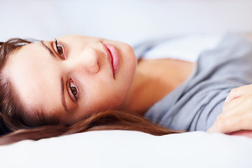 Image showing Thinking, home and woman on bed for rest, daydreaming and comfortable on weekend. Apartment, morning and face of person in bedroom to relax, nap and wake up for mental health, wellness and calm