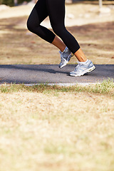 Image showing Running, workout and shoes of woman in nature for fitness, speed and cardio challenge. Wellness, sports and health with female runner training in outdoor path for exercise, fast and performance