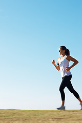 Image showing Woman running, fitness and blue sky mockup for training, workout and body wellness in nature and listening to music. Young runner or person with energy, exercise and sports health in summer and park
