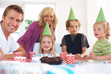 Image showing Birthday, party and a family in their home together for the celebration of a milestone with children. Smile, love or a happy mother, father and sibling kids in the living room for an event with cake