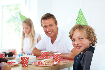 Image showing Young boy, father or portrait at birthday celebration with fun, party hats or home on weekend. Cute kid, smile face or happy man by table with cake or excited family for special event in living room