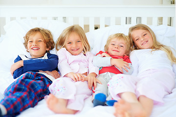 Image showing Portrait, brothers and sisters together on bed with relax wellness, happiness and sibling support in home. Boys, girls and smile face in morning in pyjamas, family bonding and love with care in house