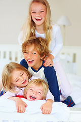 Image showing Portrait, funny or playful with brother and sister sibling kids on a bed in the home together. Family, love or laughing with young boy and girl children in the bedroom of an apartment on the weekend