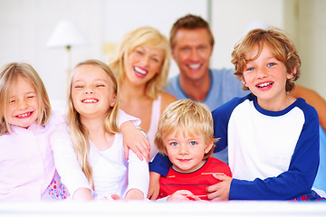 Image showing Smile, portrait and parents with children on bed for bonding, relaxing and spending time together. Happy, love and young mother and father resting with kids from Australia in bedroom at family home.