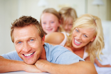 Image showing Portrait, funny and a family lying on a bed together while in their home on a weekend morning. Face, love and father, mother and children laughing in the bedroom of an apartment to relax for bonding