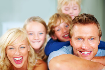 Image showing Portrait, funny and a happy family on a bed together while in the home on a weekend morning. Face, smile or love with a father, mother and children in the bedroom of an apartment to relax for bonding