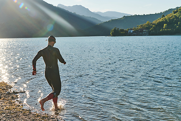 Image showing Triathlon athlete starting swimming training on lake