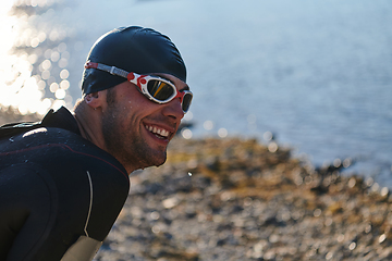 Image showing Authentic triathlon athlete getting ready for swimming training on lake