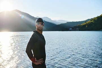 Image showing Authentic triathlon athlete getting ready for swimming training on lake