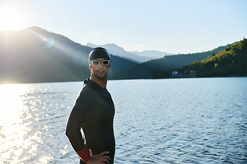 Image showing Authentic triathlon athlete getting ready for swimming training on lake