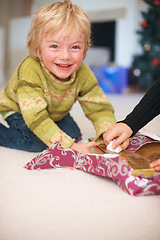 Image showing Portrait, boy and opening christmas presents for holiday, happy and excited for gift. Celebration, smile and family home with decorations, tradition and joy for santa claus or childhood memories