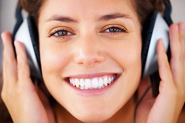 Image showing Smile, headphones and face of young woman listening to music, playlist or radio at home. Happy, technology and closeup of female person from Canada relax and streaming song or album in her apartment.