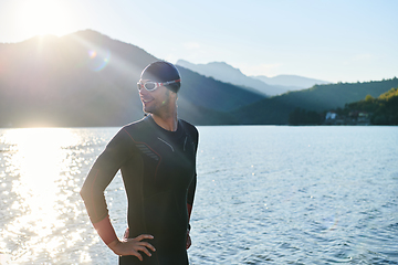 Image showing Authentic triathlon athlete getting ready for swimming training on lake