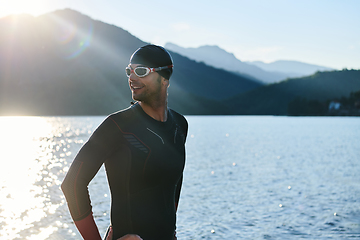 Image showing Authentic triathlon athlete getting ready for swimming training on lake