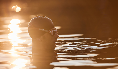 Image showing A triathlete finds serene rejuvenation in a lake, basking in the tranquility of the water after an intense training session