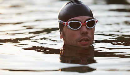 Image showing A triathlete finds serene rejuvenation in a lake, basking in the tranquility of the water after an intense training session