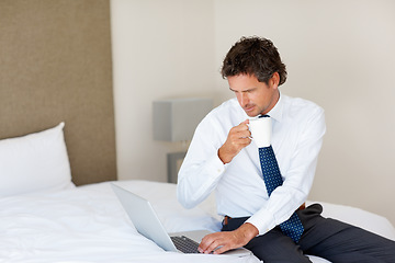 Image showing Laptop, bedroom and tea with a businessman getting ready for work at his home in the morning while checking an email. Corporate, computer on a bed and an employee drinking coffee in an apartment