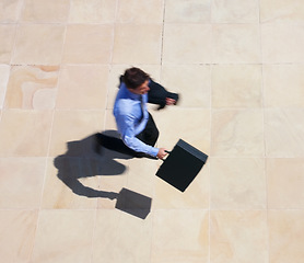 Image showing Running, late and a business man rushing to work for an appointment with a briefcase from above. Panic, fast and delay with a professional employee in a hurry to get to his destination in the city