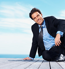 Image showing Relax, thinking and sea with a business man on a pier against a blue sky background for company vision. Smile, idea and future with a happy corporate employee in a suit on a boardwalk by the ocean