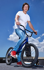 Image showing Sky, bicycle and portrait of boy teenager riding for fitness, health or wellness in the road. Smile, sports and young man cycling on bike for transportation, adventure and adrenaline for practice.