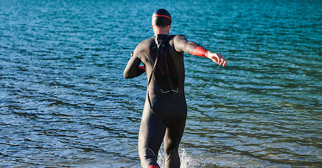 Image showing Triathlon athlete starting swimming training on lake