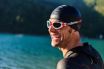 Image showing Authentic triathlon athlete getting ready for swimming training on lake