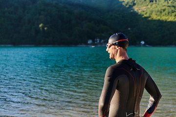 Image showing Authentic triathlon athlete getting ready for swimming training on lake