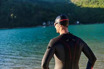 Image showing Authentic triathlon athlete getting ready for swimming training on lake