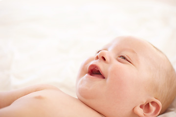 Image showing Baby, smile on bed and funny laugh of young child in development, innocent and relax at home. Happy kid, excited infant in nursery and rest in bedroom, healthy body and cute, adorable or mockup space