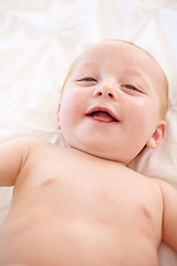 Image showing Happy baby on bed, funny and top view portrait of young child in development, excited or relax at home. Face, above and infant kid laugh in nursery, rest in bedroom or healthy body, cute or adorable