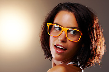 Image showing Woman, face and closeup with glasses in studio for vision, sight and trendy fashion mock up on brown background. Female model, confident or pose for wow, surprise or omg for cool, chic or spectacles