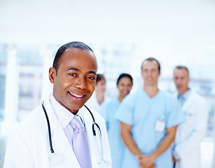 Image showing Doctor, black man and portrait of expert with medical, healthcare and clinic staff in a hospital. Teamwork, medicine job and stethoscope of nurse and surgeon with professional team ready for working