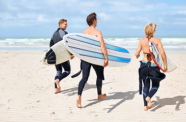 Image showing Surfer friends, running and back at beach with board, training or fitness on vacation in summer. Men, woman and surfboard for wellness, health or workout by ocean, waves or freedom on holiday on sand