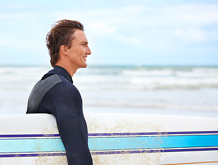 Image showing Surfer man, walking and smile at beach with space, waves and outdoor with thinking, vision and exercise. Person, surfboard and freedom with ideas for workout, adventure or wellness in summer by ocean
