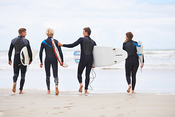 Image showing Surfer friends, walking and back at beach with board, training and fitness on vacation in summer. Men, woman and group for wellness, health or workout by ocean, waves and freedom for holiday on sand