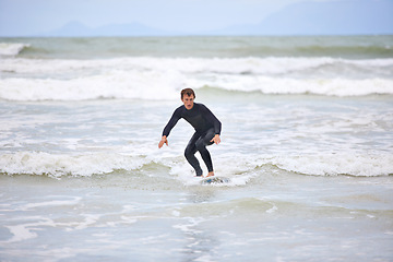 Image showing Surfer man, waves and board with balance, fitness and training for health, wellness and freedom in summer. Person, surfing and outdoor for sports, exercise and adventure at sea, ocean and sunshine