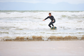 Image showing Surfer man, ocean and board with balance, fitness and training for health, wellness and freedom in summer. Person, surfing and outdoor for sports, exercise and adventure at sea, waves and sunshine