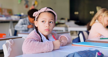 Image showing Child, thinking and pen with paper by desk, education and solving a mathematics problem with question. Young student, confused and solution to assessment in classroom, elementary school and academy