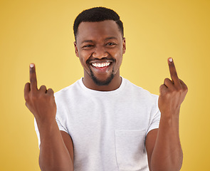 Image showing Happy, middle finger and portrait of black man in studio with rude, insulting and bad sign. Emoji, symbol and face of person with hand gesture on yellow background for joke, rebel attitude and laugh