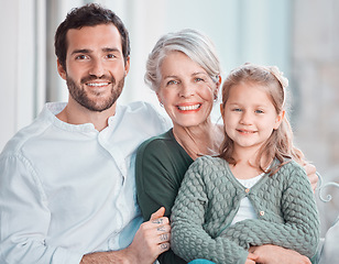 Image showing Father, grandmother and girl with smile in portrait, hug and care with love, bonding and relax on chair. Dad, elderly woman and child with embrace, happy together and living room in family house