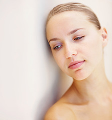 Image showing Thinking, beauty and space with a young woman on a wall background for wellness or natural treatment. Relax, skincare and idea with a person at the spa or salon for dermatology or self care on mockup