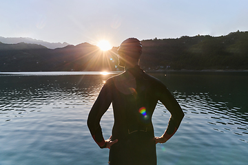 Image showing Authentic triathlon athlete getting ready for swimming training on lake