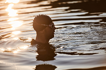 Image showing A triathlete finds serene rejuvenation in a lake, basking in the tranquility of the water after an intense training session