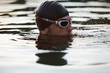 Image showing A triathlete finds serene rejuvenation in a lake, basking in the tranquility of the water after an intense training session