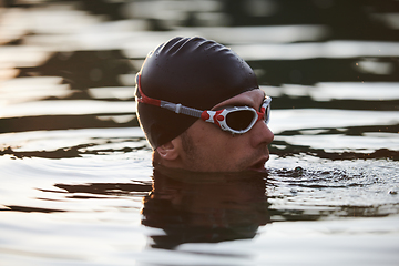 Image showing A triathlete finds serene rejuvenation in a lake, basking in the tranquility of the water after an intense training session