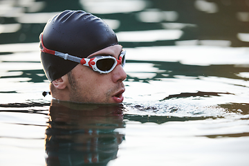 Image showing A triathlete finds serene rejuvenation in a lake, basking in the tranquility of the water after an intense training session